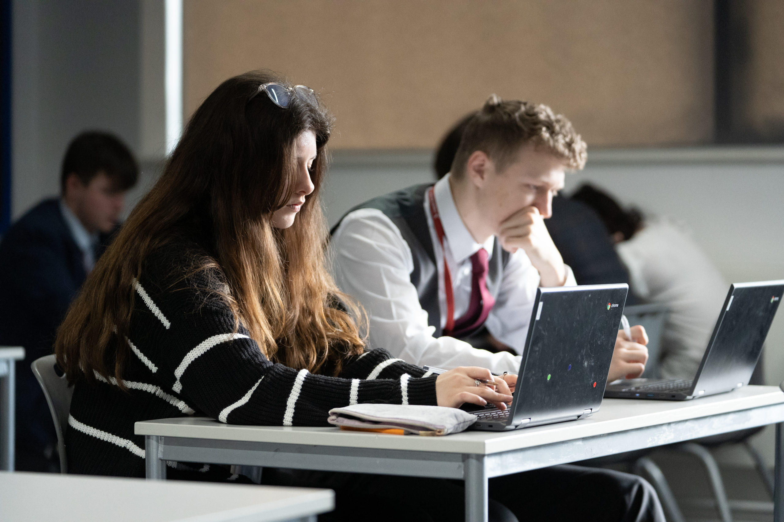 Two students working on their school work using a chromebook