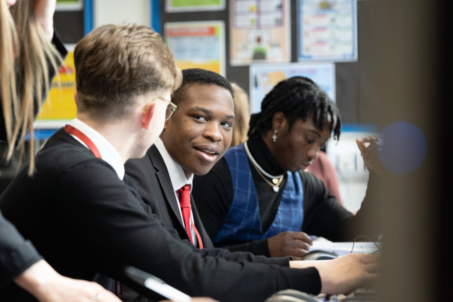 Three students working in class on computers