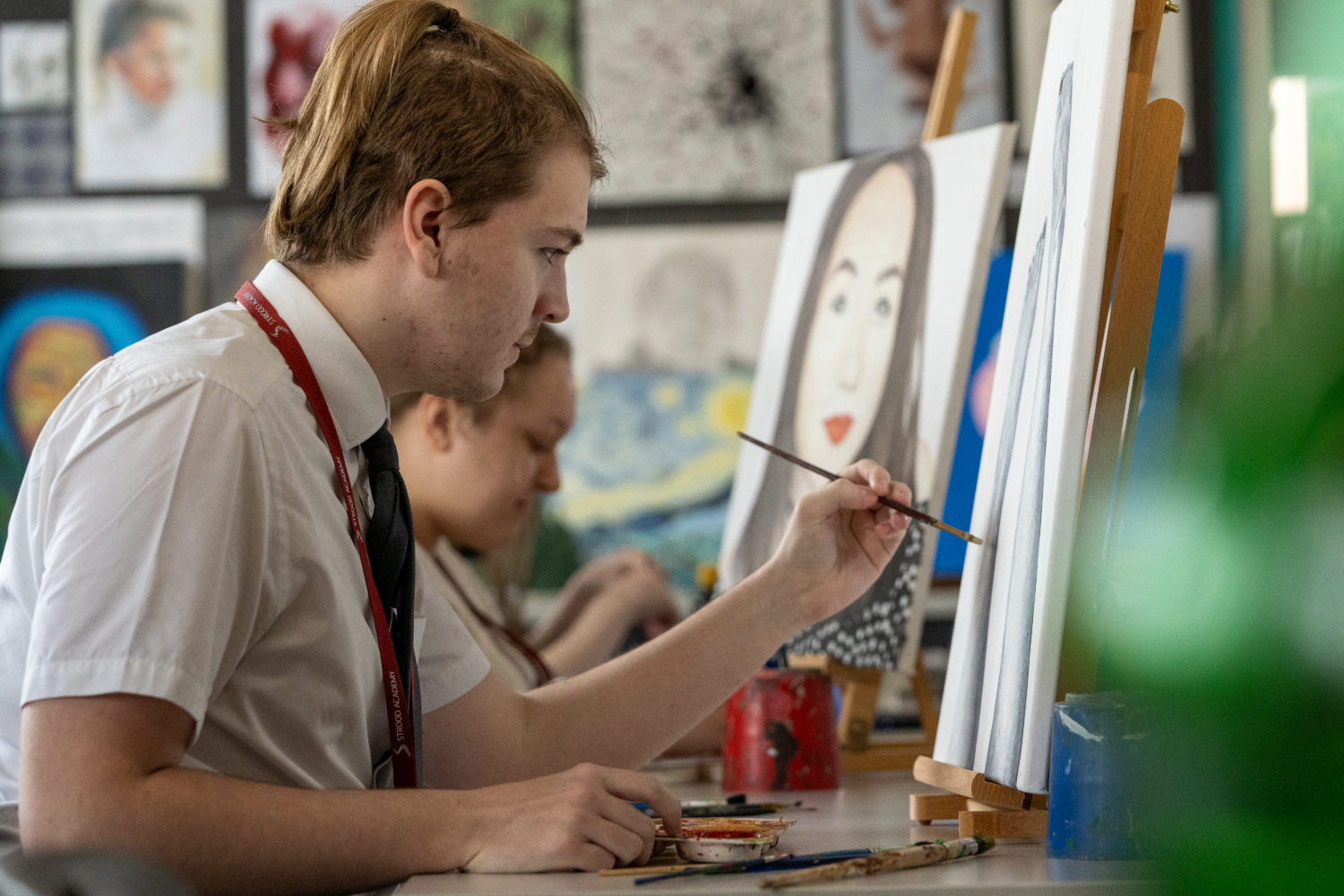 Close up of a student painting on a canvas
