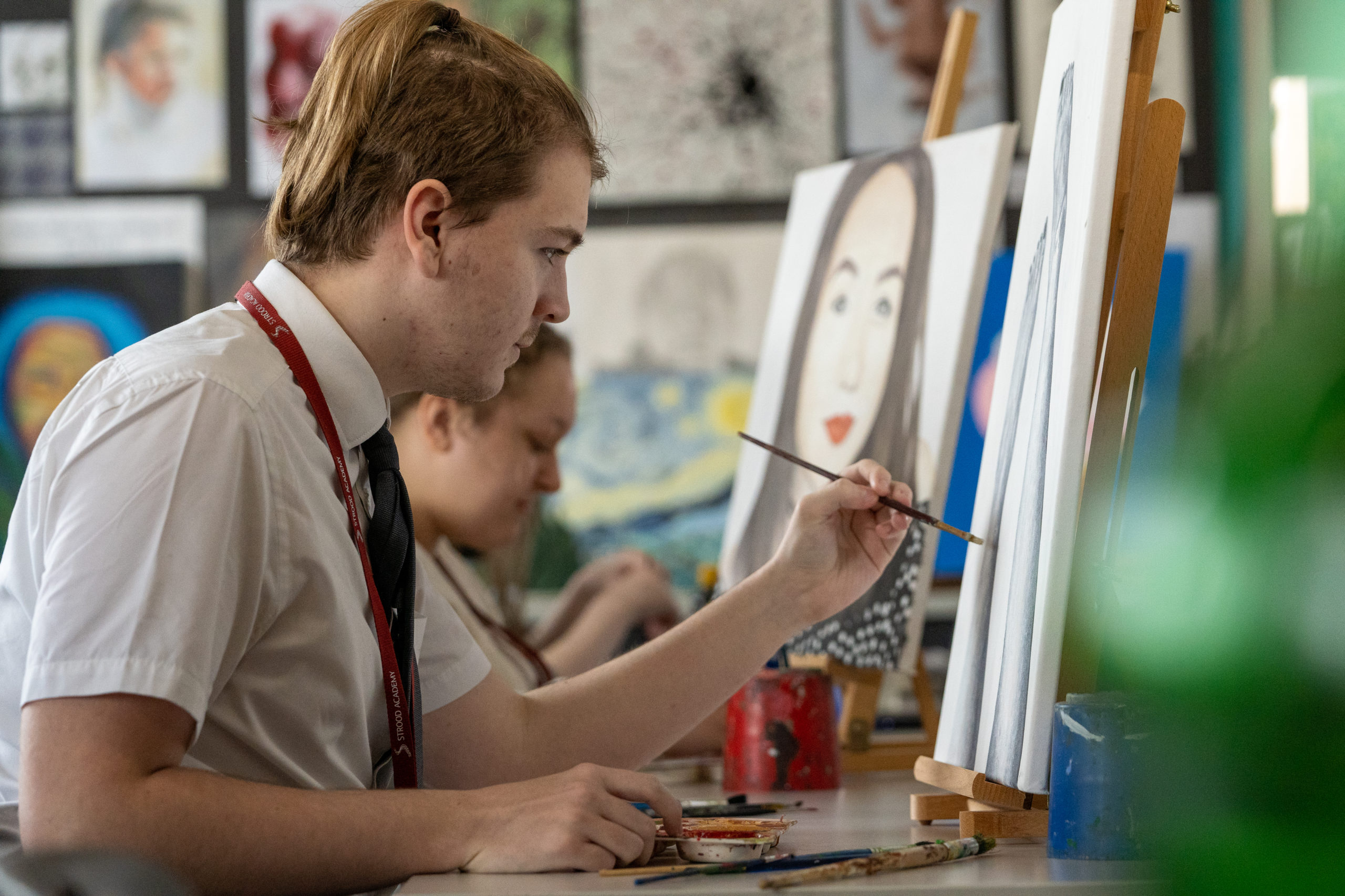 Close up of a student painting on a canvas