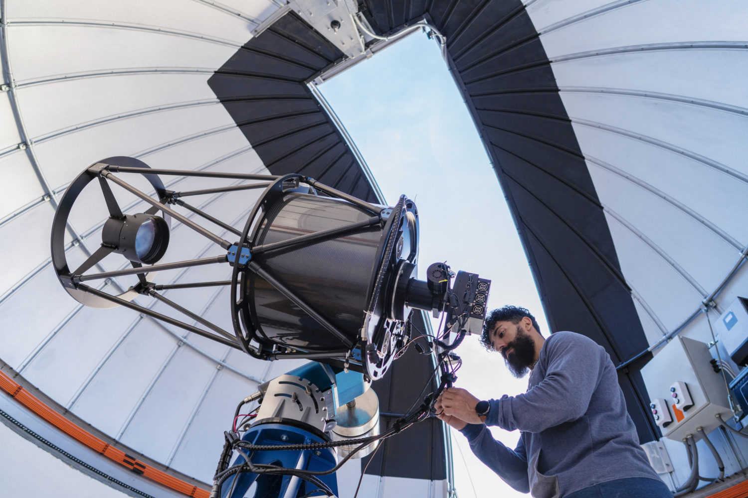 Astronomer in photo telescope dome daylight checking settings for the coming night