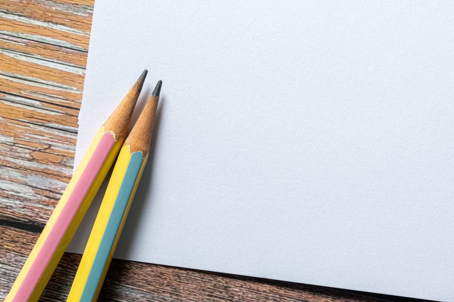 Template with copy space by top view close up macro photo of wooden yellow pencil isolated on white paper and combine with yellow brush. Flash light made smooth shadow from yellow pencil.
