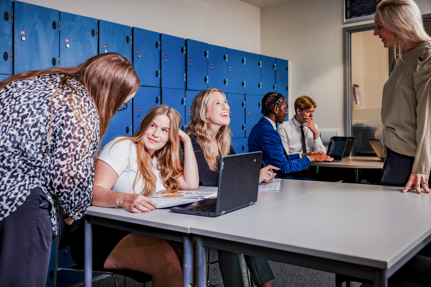 Two Sixth Form students completing their work talking to teachers
