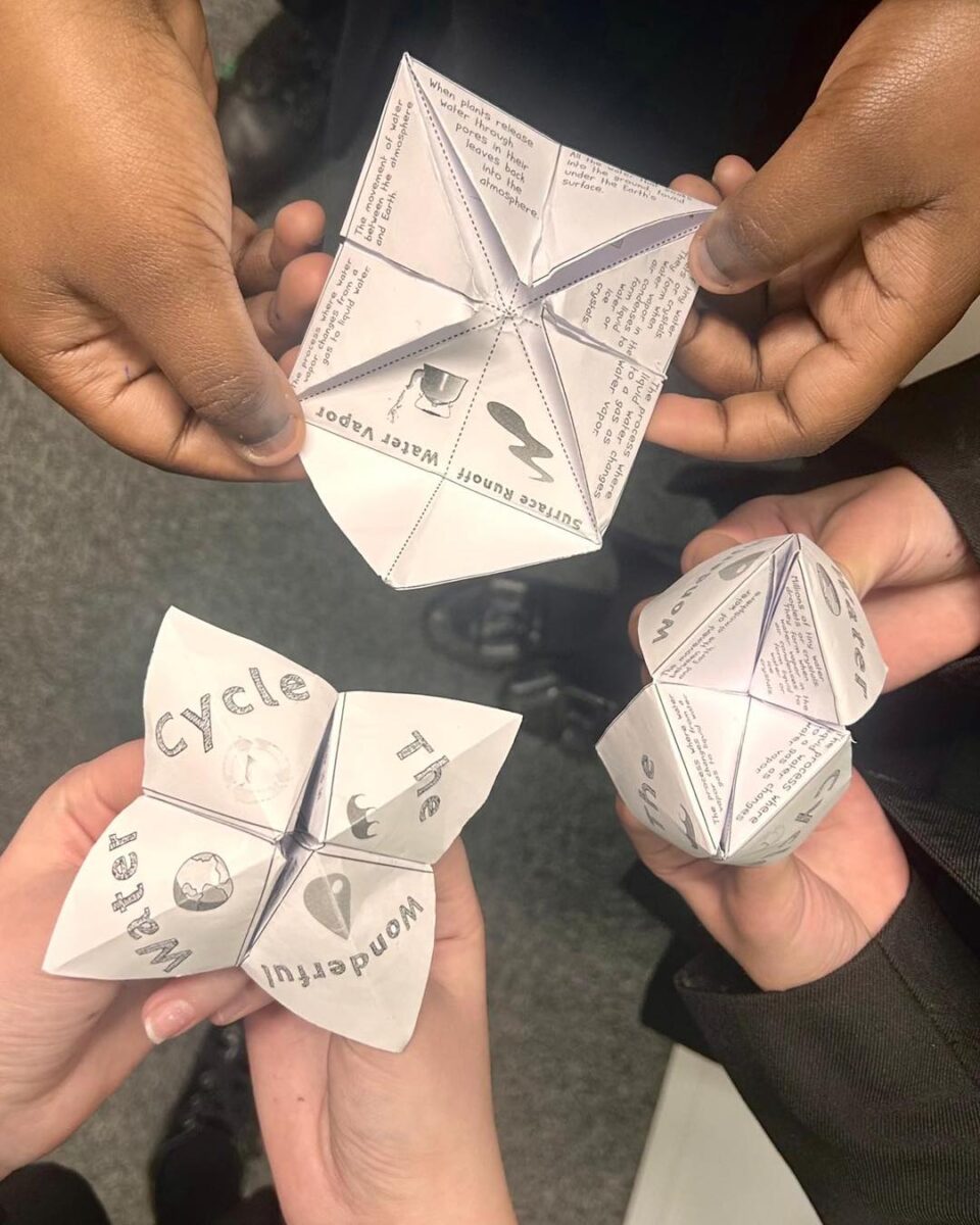 3 students holding paper 'chatter boxes'