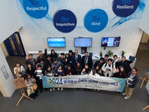A group of people smiling for a photo and holding up a banner